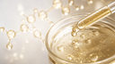 Goccia di siero alla vitamina C dorata in capsula di vetro, macro scientifica Chrissie Cosmetics